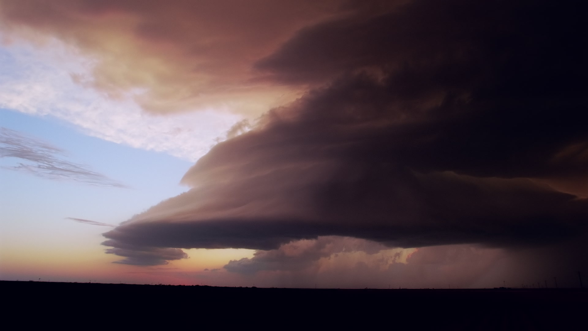 Storms on 35 - Orange supercell and lightning, dusk, Texas. Super 35mm film to 4K video. Cinematographer: Martin Lisius. Need more? Give us a shout!