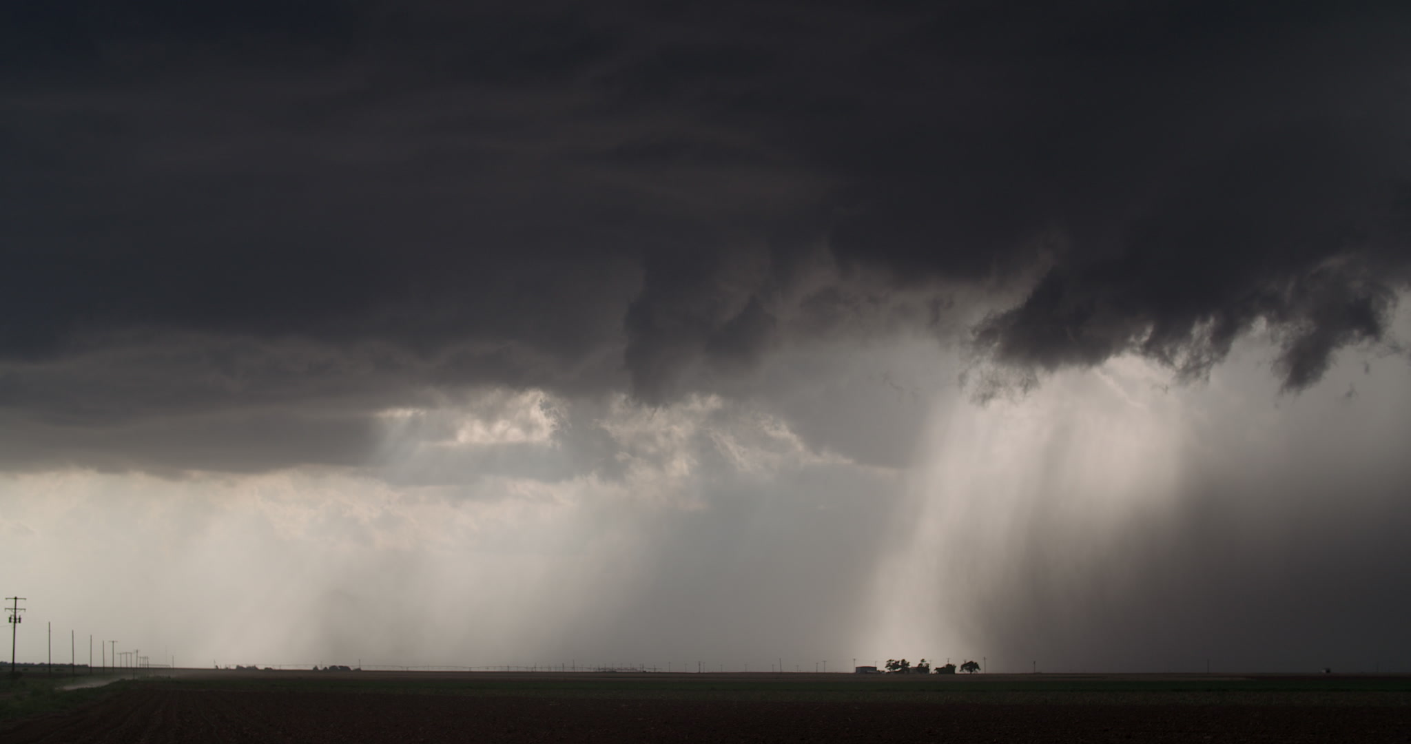 Storm clouds - Shaft of light shines on farm beneath storm, 4K. Cinematographer: Martin Lisius. DCI 4K. Need more storm shots? Contact us.