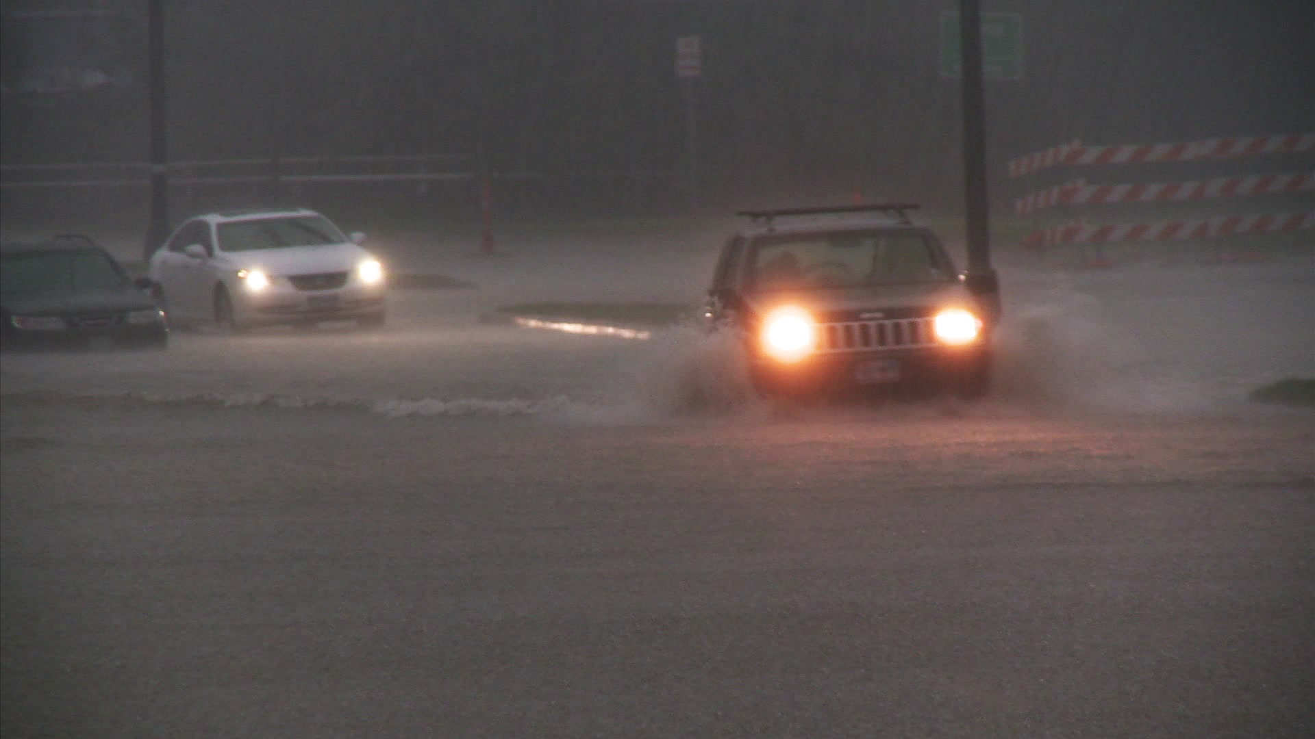 Urban flooding - Jeep drives through flooded street.