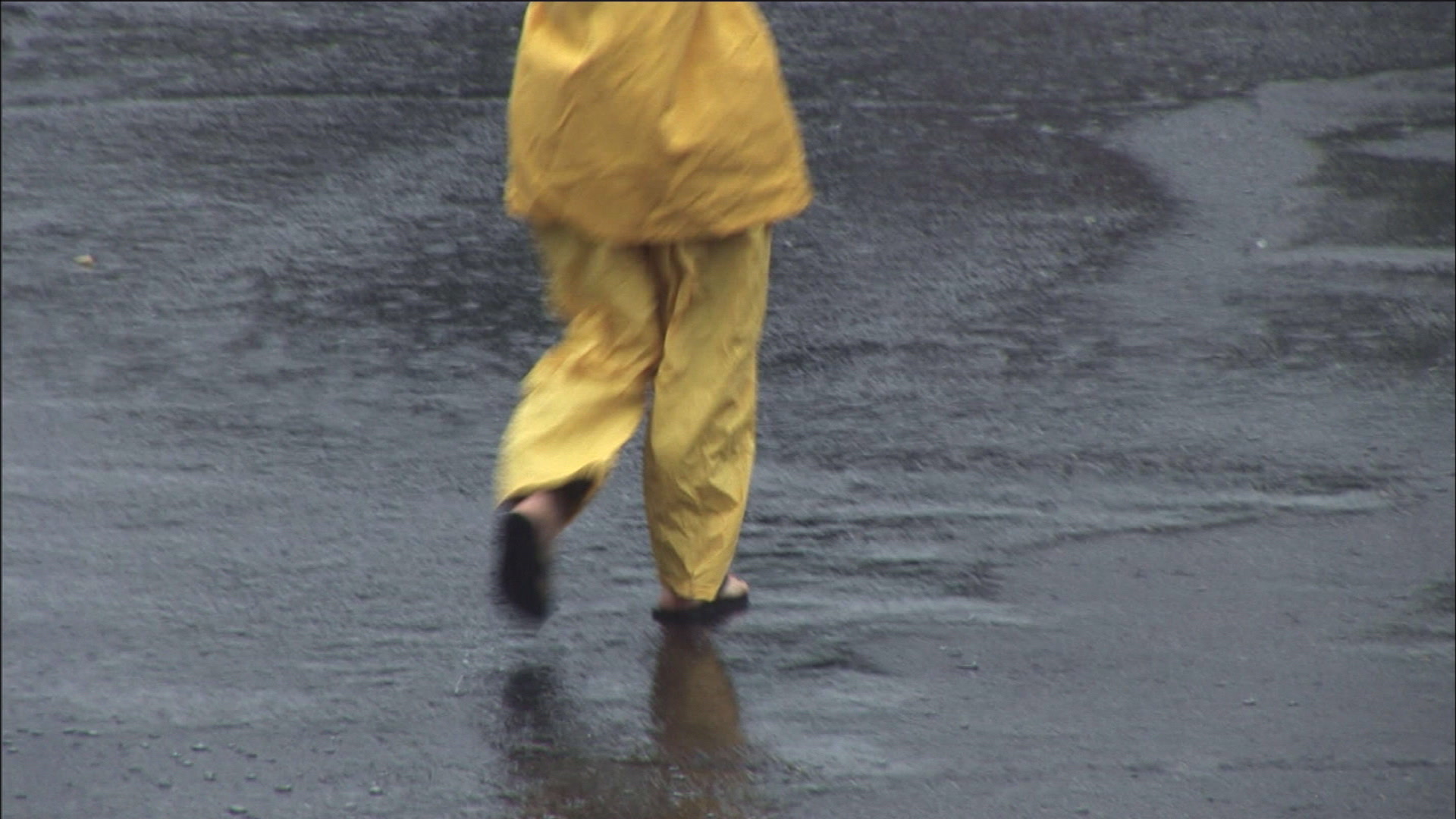 Woman walks in rain as Hurricane Katrina arrives, HD video.