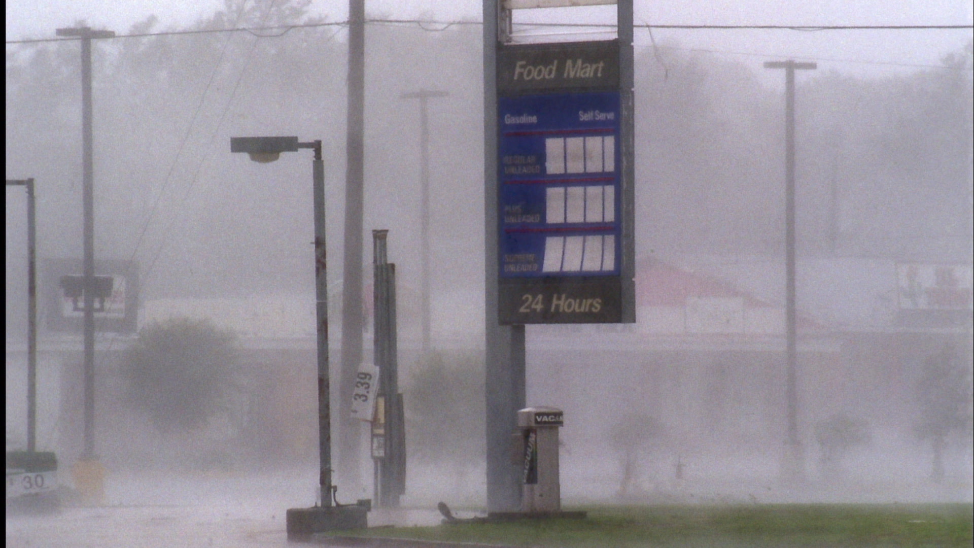 Wind, rain, flying debris blow past food mart sign, Hurricane Katrina, Super 35mm film to HD video. Cinematographer: Martin Lisius.