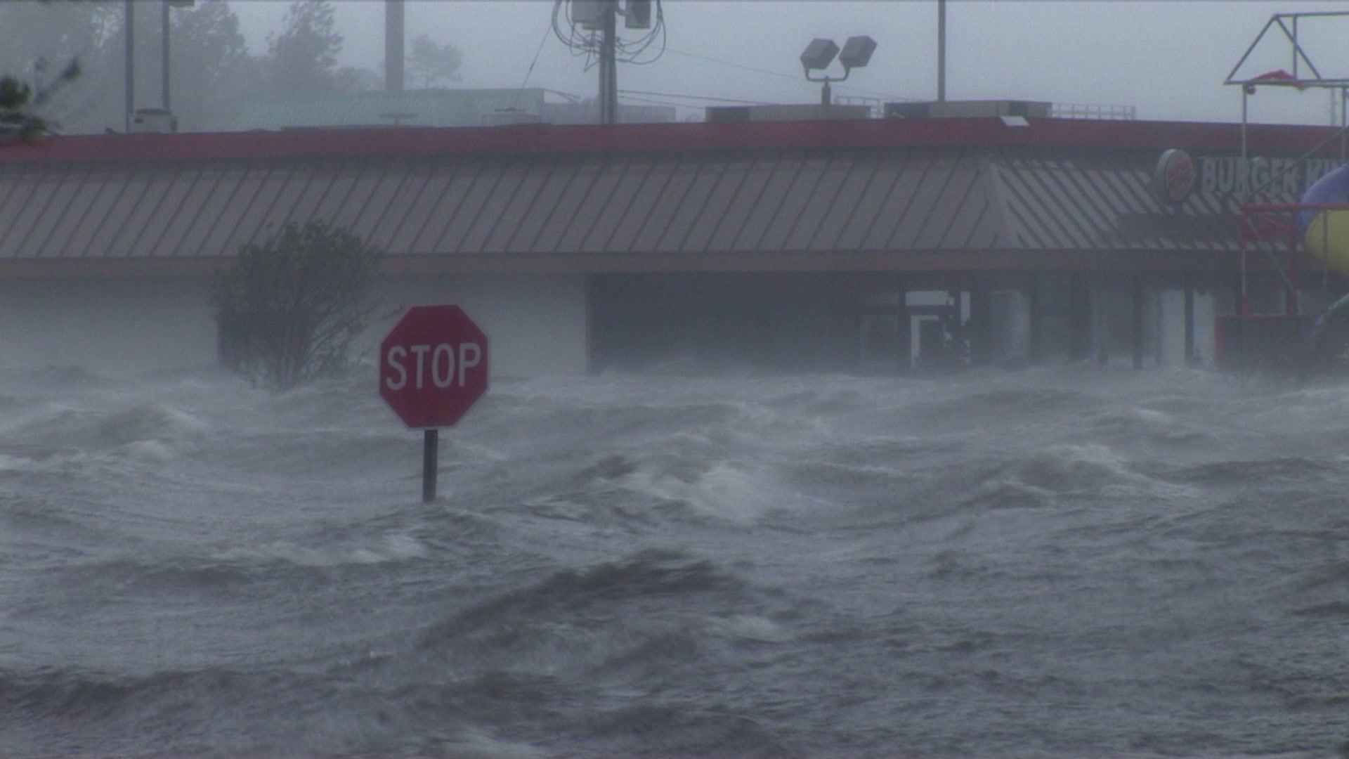 Amazing shot of record storm surge in parking lot, stop sign, Hurricane Katrina, 4K. Cinematographer: Martin Lisius.