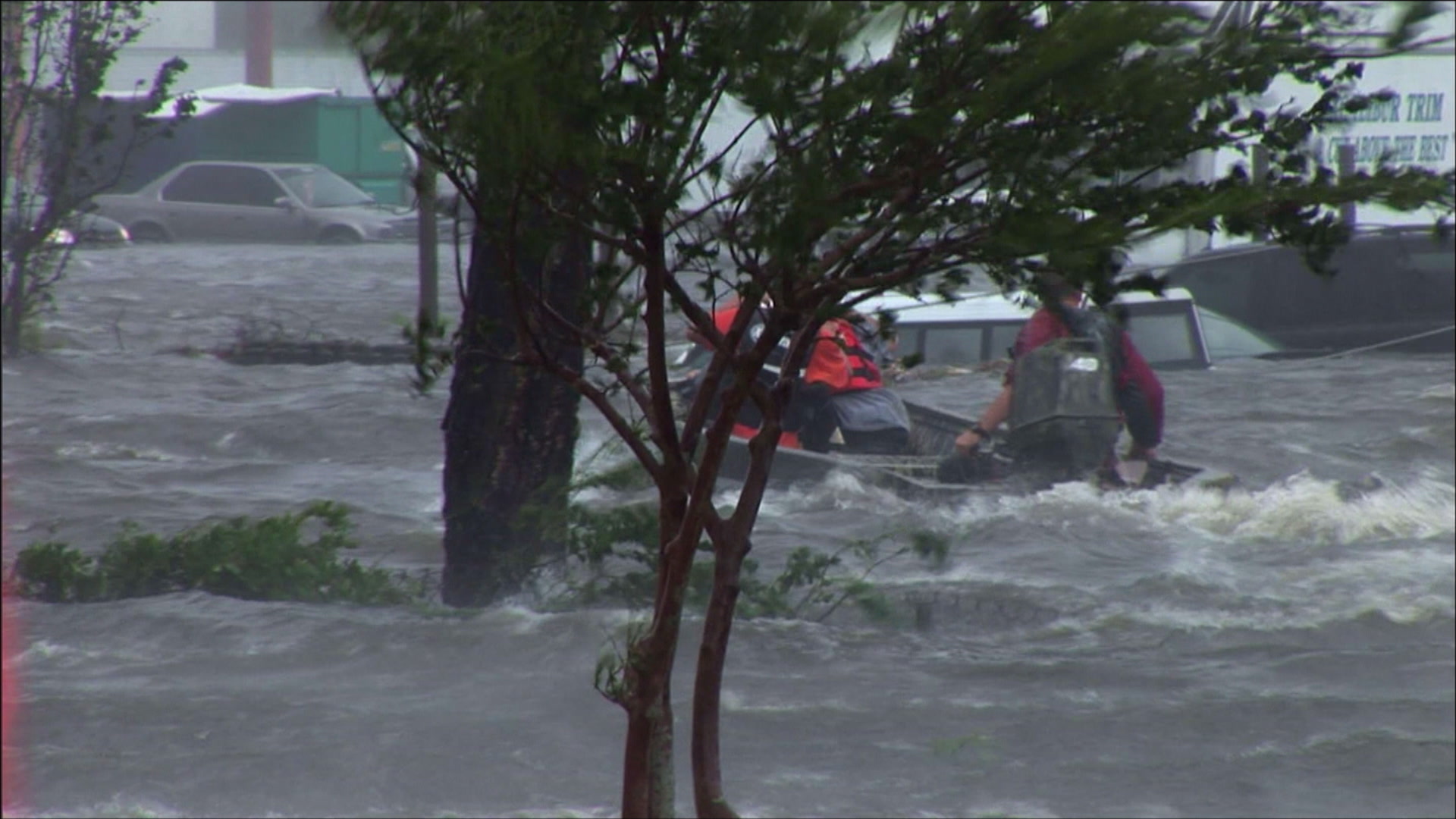 High water rescue team passes behind trees, intense wind, surge, Hurricane Katrina, 4K. Cinematographer: Martin Lisius.