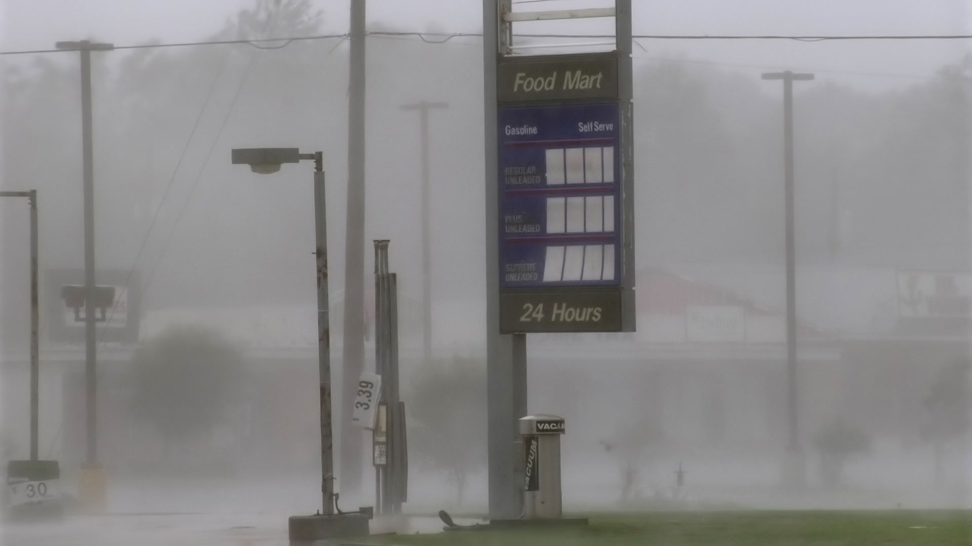 Intense wind and rain blow past food mart sign, Hurricane Katrina, Super 35mm film to 4K video. Cinematographer: Martin Lisius.