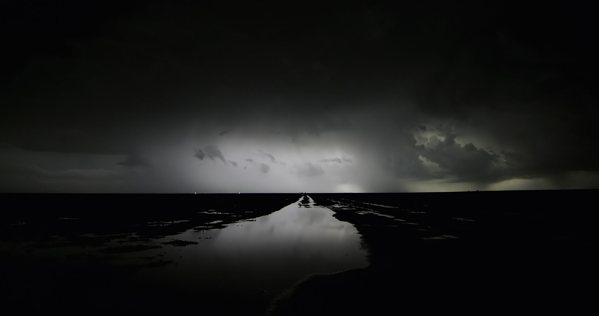 Beautiful, dramatic shot of continuous lightning storm over flooded farm road, Kansas, 4K. Cinematographer: Martin Lisius. Camera: RED DSMC Dragon 5K.