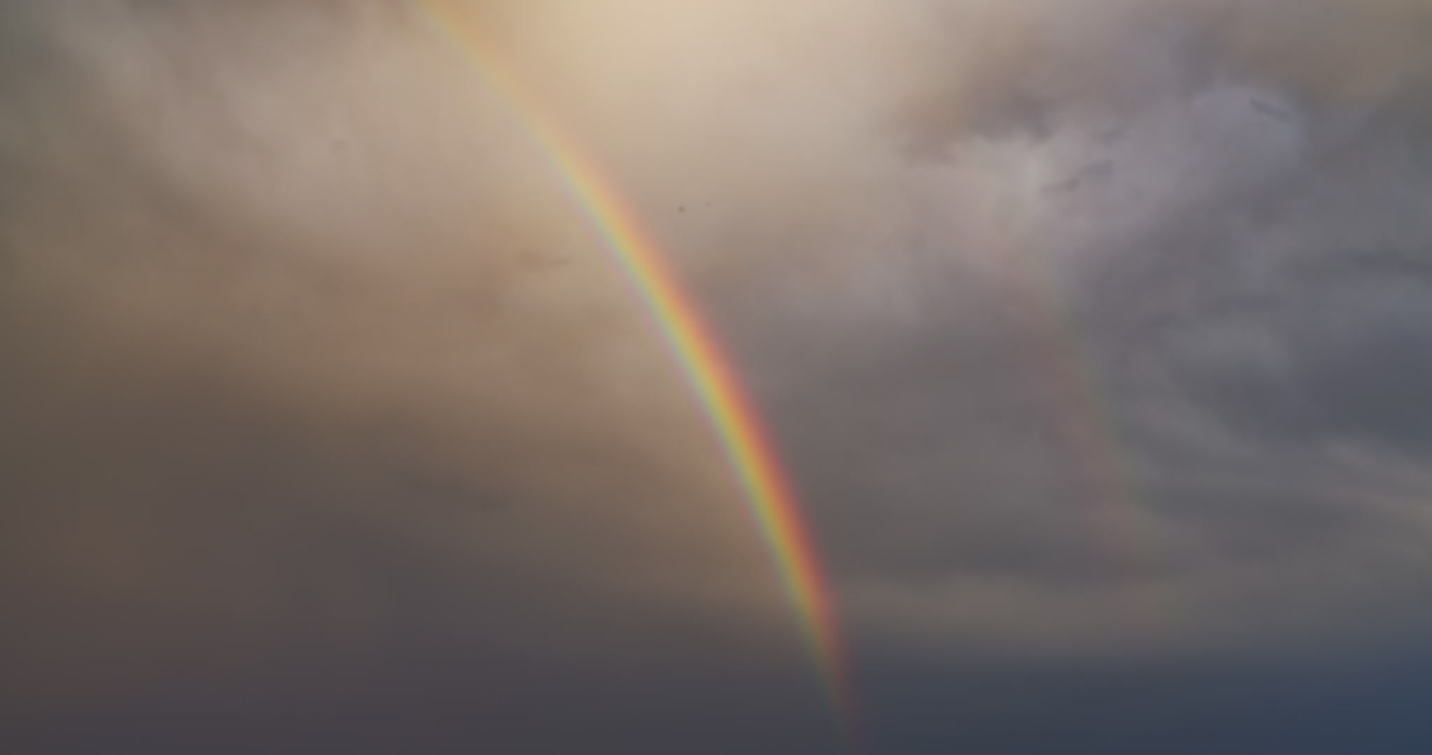 Close-up of rainbow in stormy sky, real-time, 4K. DCI 4K.