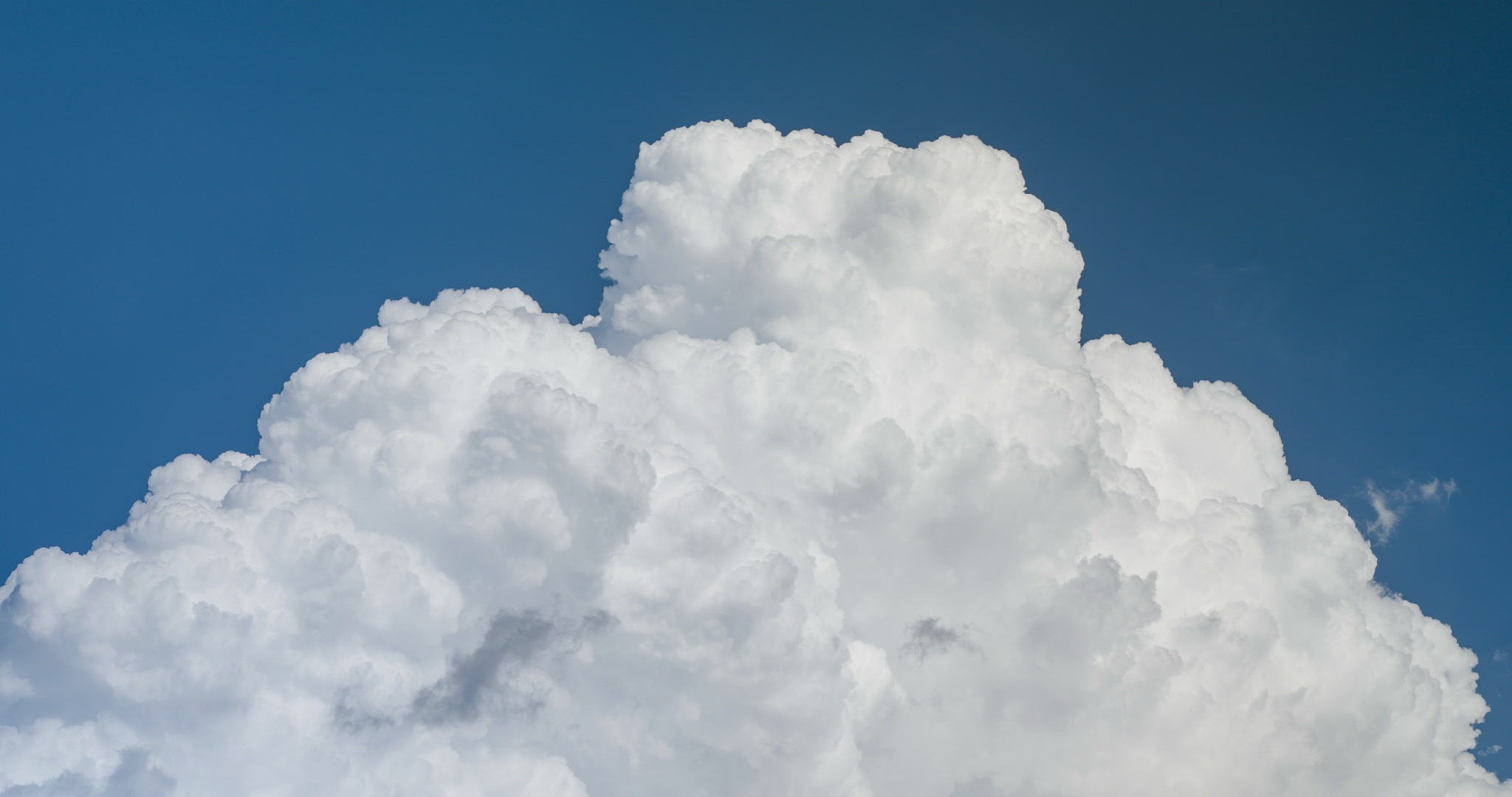 Large towering cumulus cloud, blue sky, day, real-time. DCI 4K.