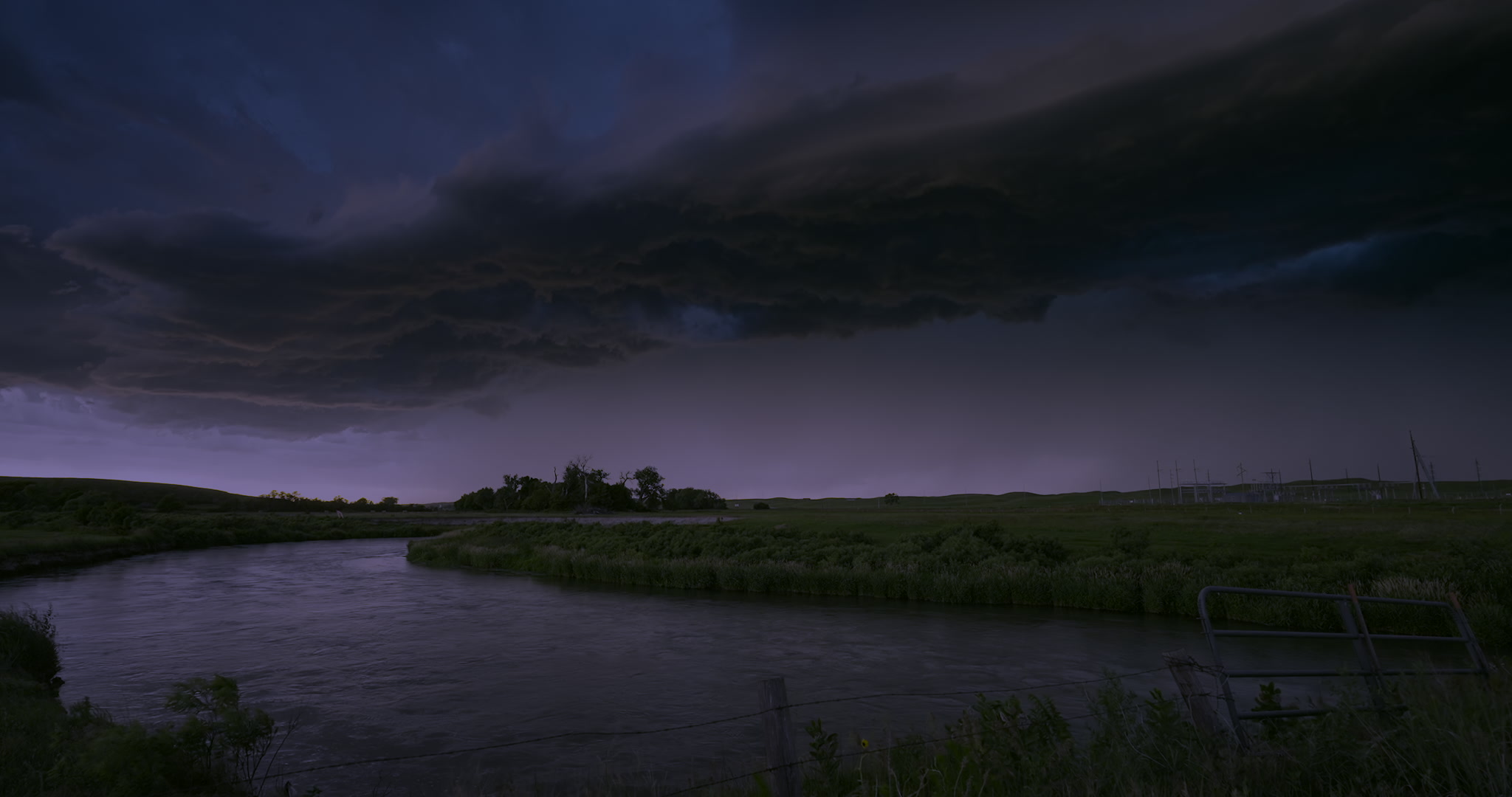 Severe storm approaches over river, big lighting bolt, night. DCI 4K.