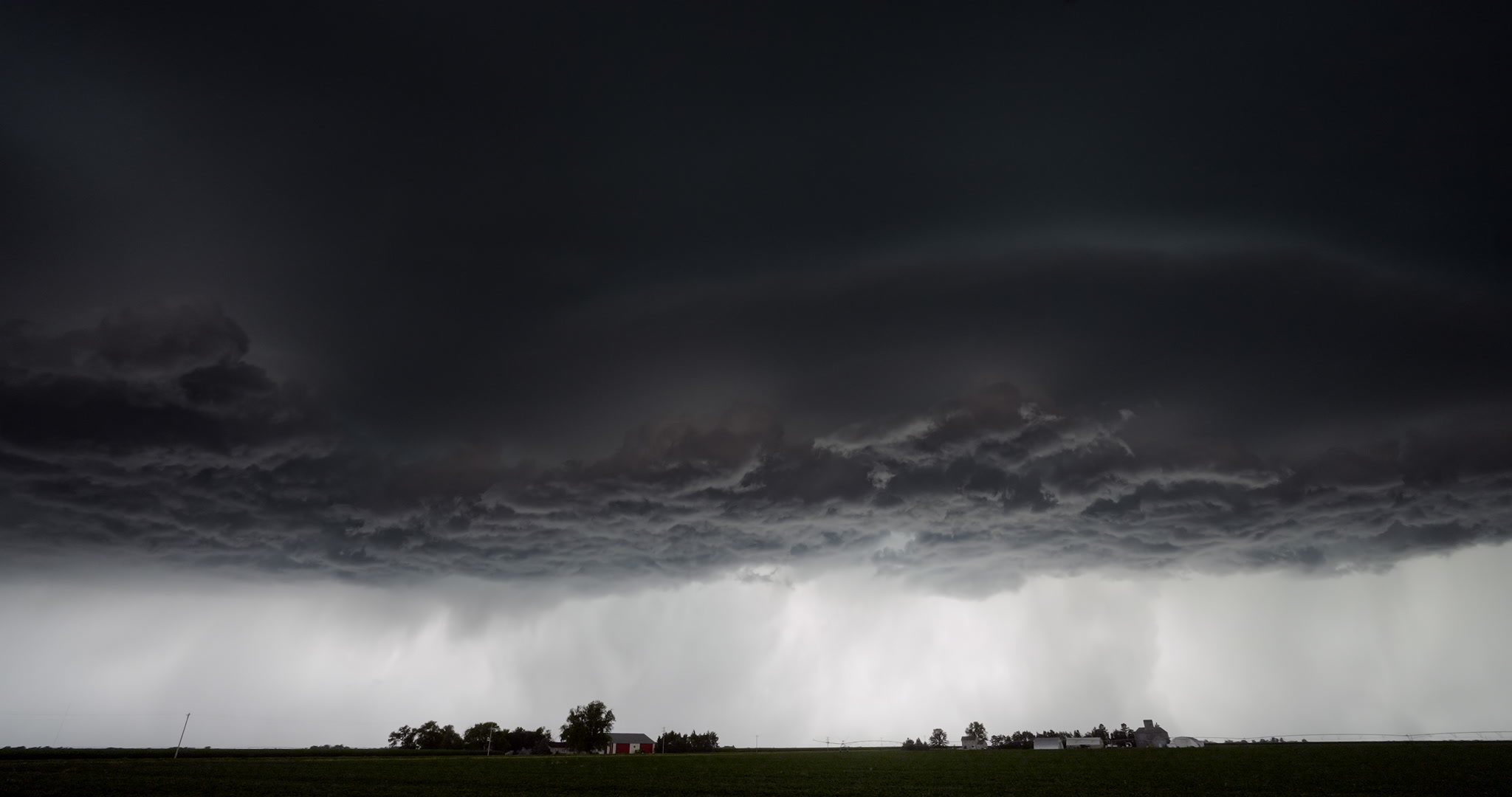 Time-lapse, big, spinning supercell over two farms. DCI 4K.