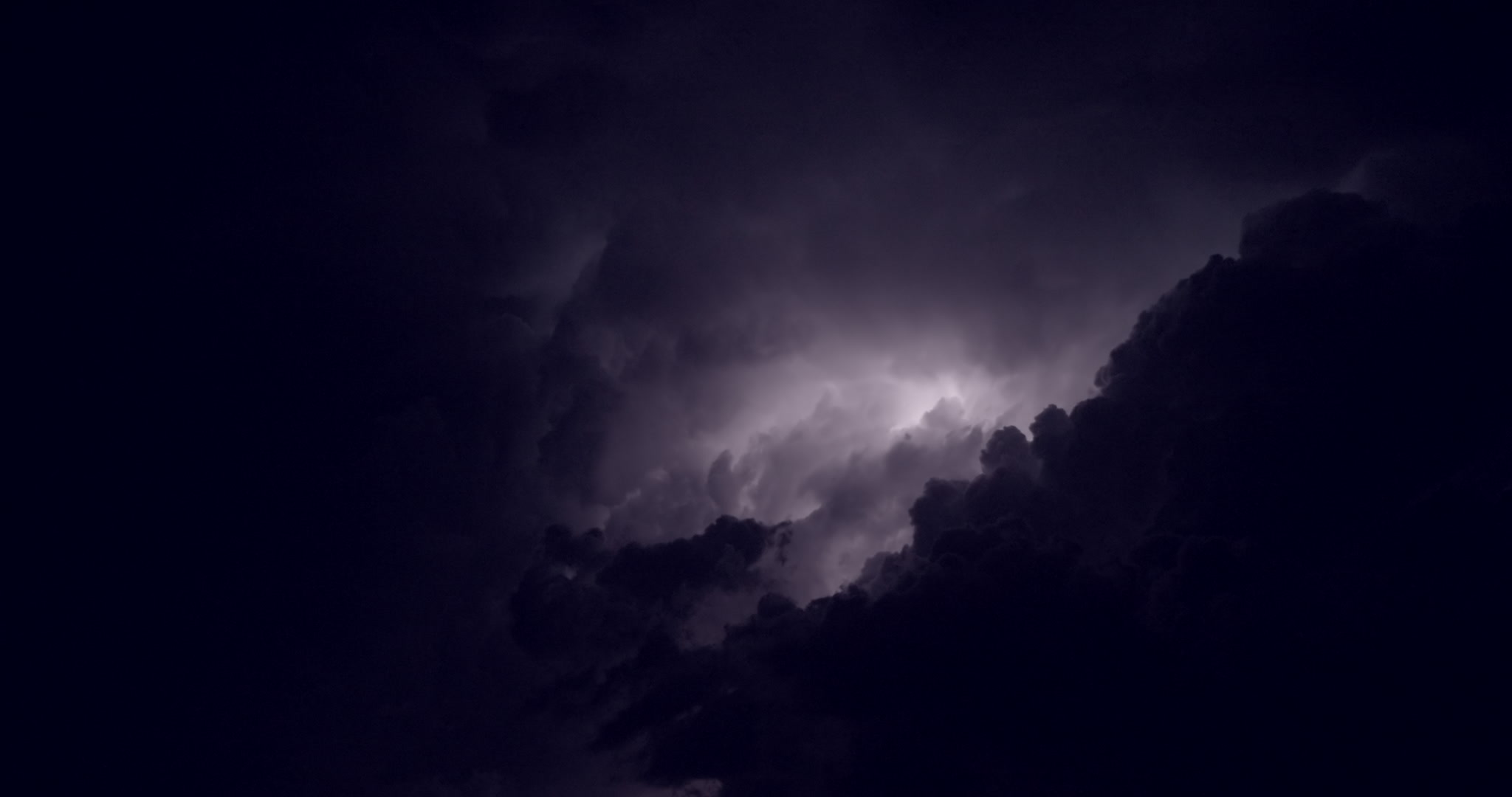 Big flashes of lightning, top of severe storm, night. Real-time. DCI 4K.