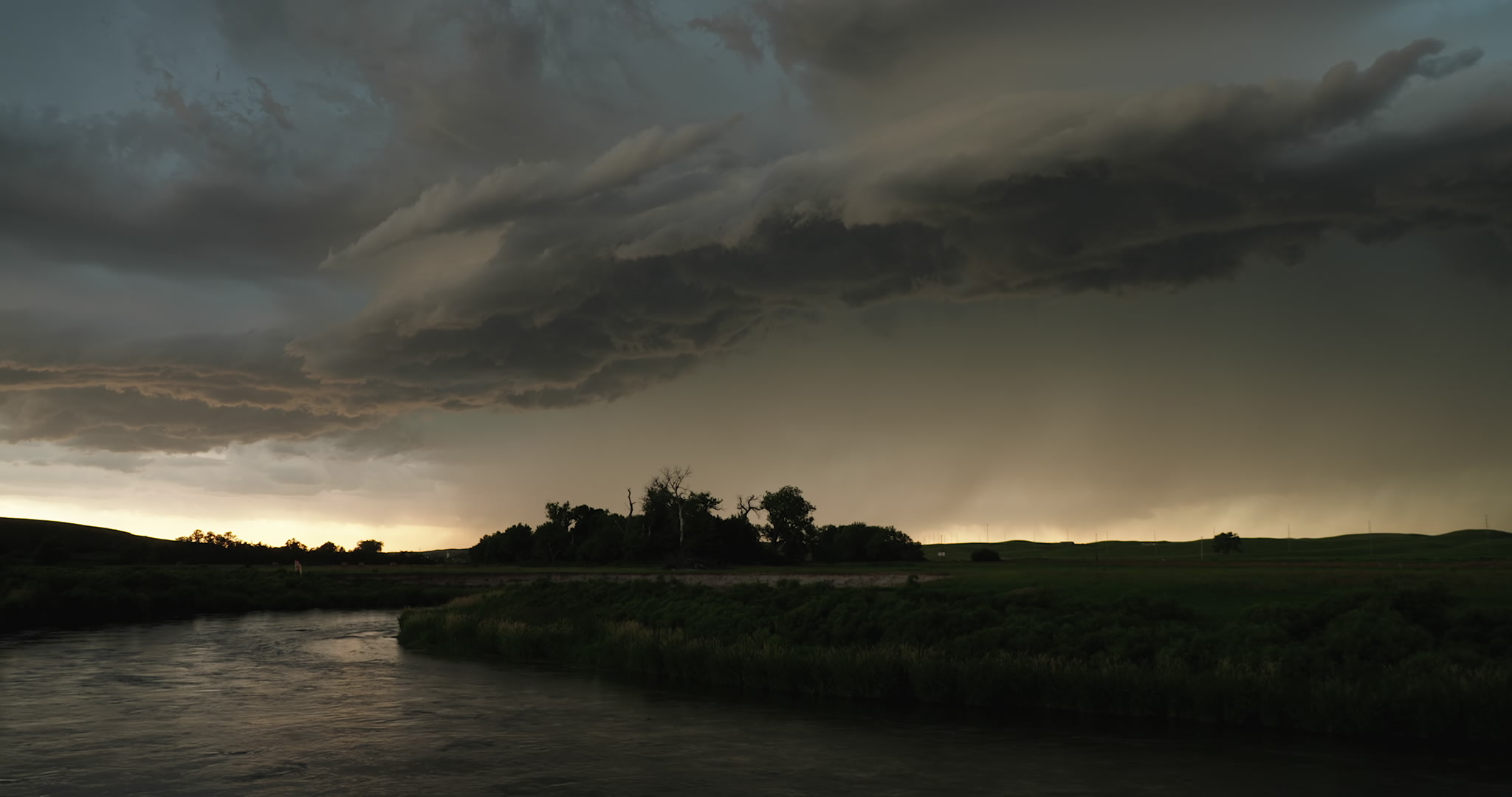 Lightning flashes, dark storm approaching, Middle Loup River, Nebraska, real-time. DCI 4K.
