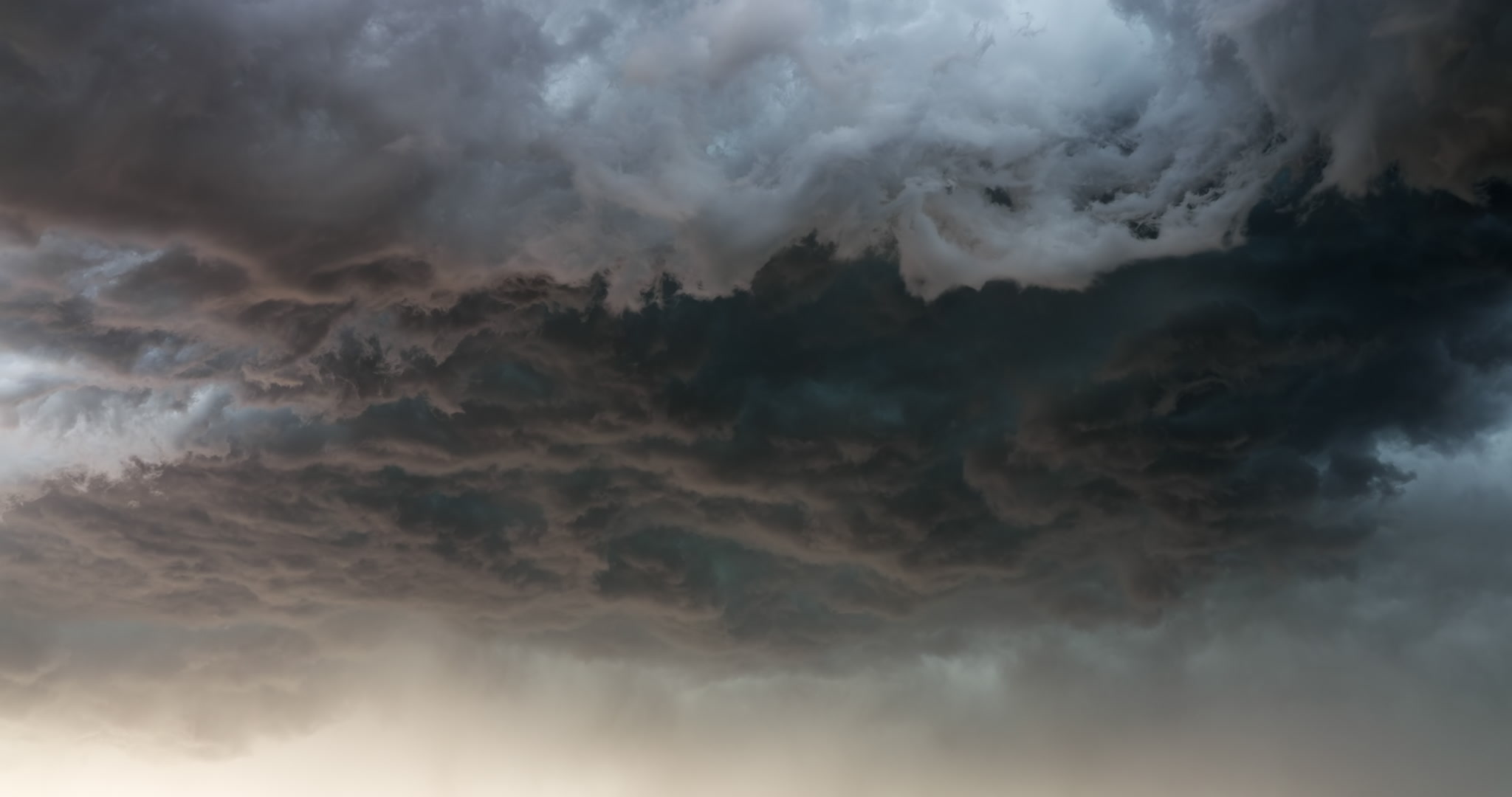 Dark, scary, inky gray and teal storm clouds boil as they approach. DCI 4K.