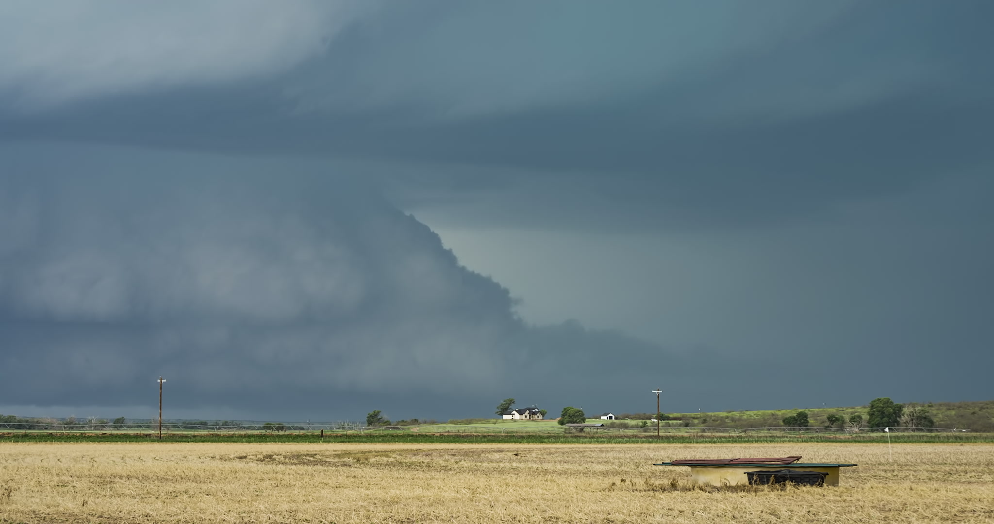 Large supercell thunderstorm with big bolts of lightning approaches Texas farm. DCI 4K.