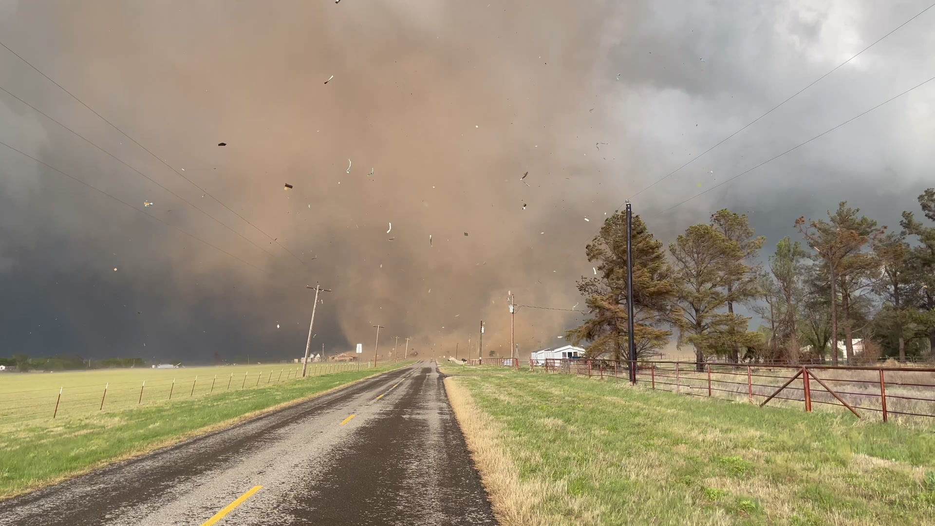 Red tornado strikes several structures near rural highway, Lockett, Texas, 4K.
