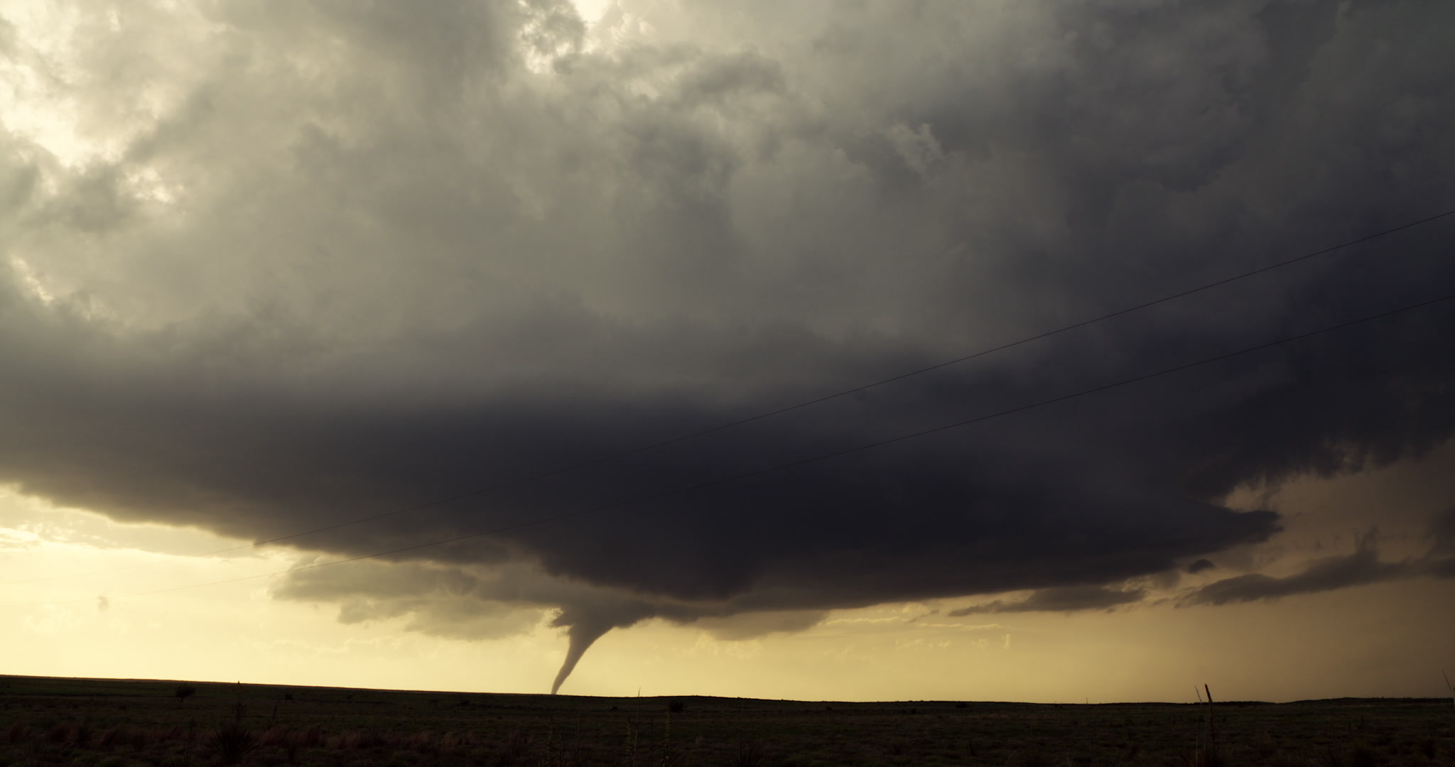 Tornado - wide shot of tornado beneath supercell thunderstorm, Oklahoma prairie, 4K.