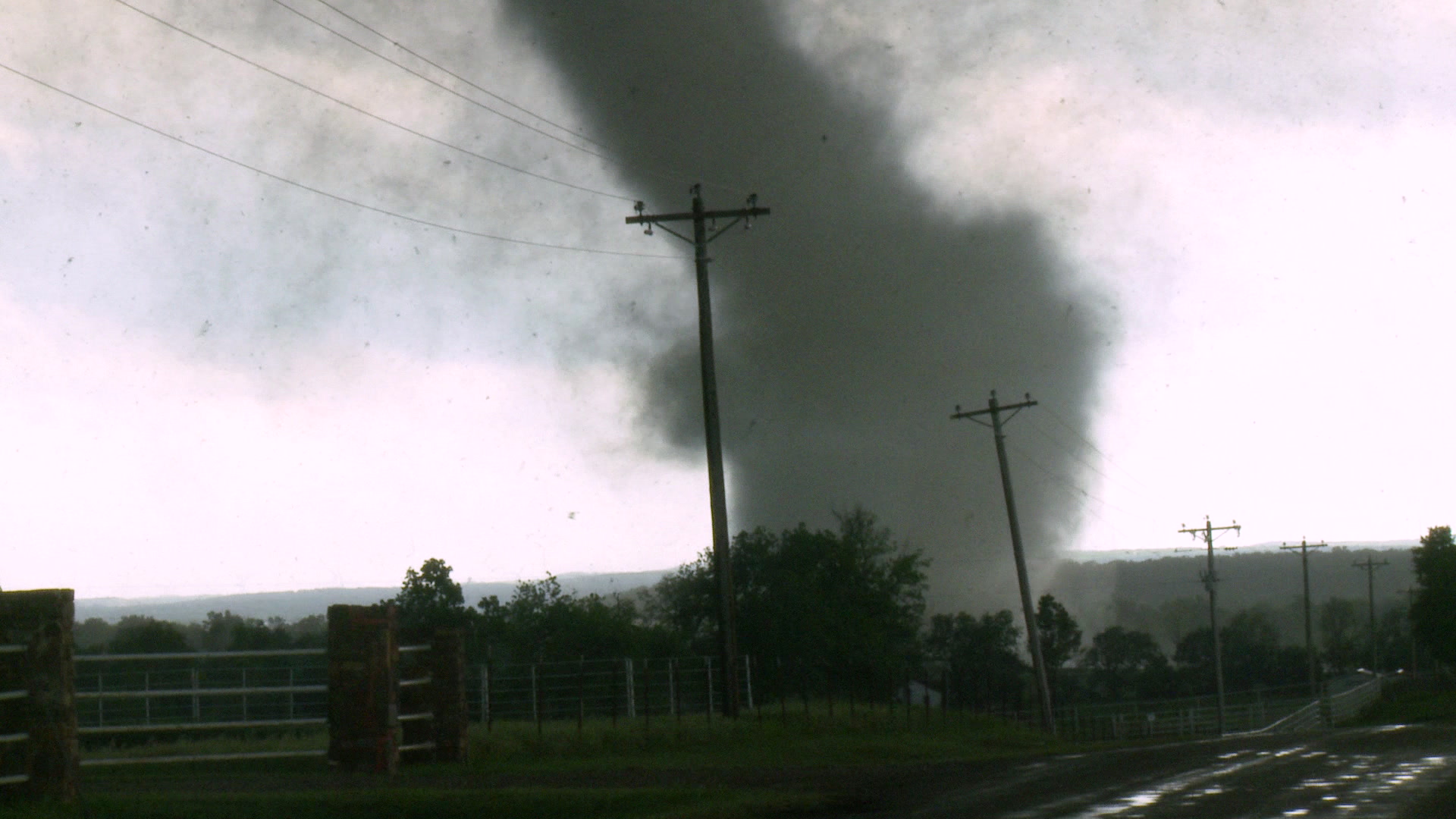 Tornado - zoom in, passes behind power lines.