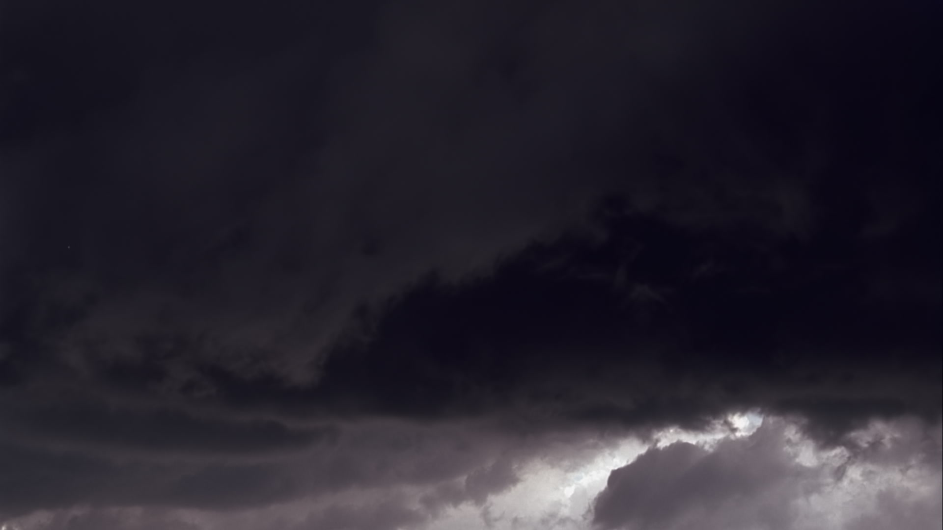 Dark gray storm clouds filled with lightning at dusk - Super 35mm film to HD 1080.